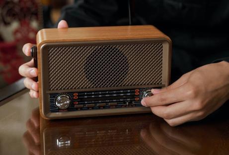 Person tuning a vintage-style radio.