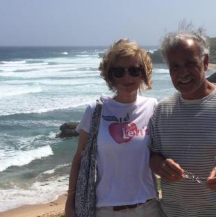 Couple standing on beach, woman wearing Levi's shirt.