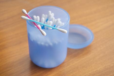 Multicolored cotton swabs in a blue container.