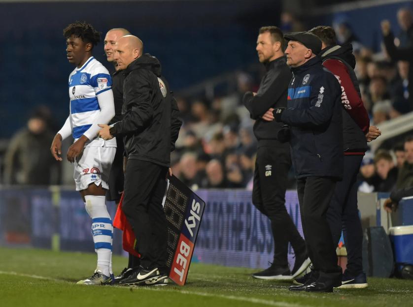 Soccer managers and a player on the sidelines.