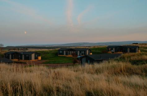 Lodges on a hill at sunset.