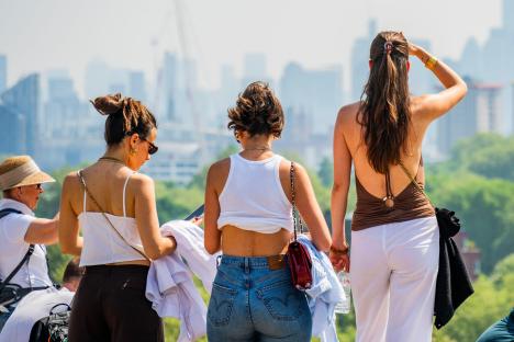 Three women enjoying a sunny day, overlooking a city skyline.