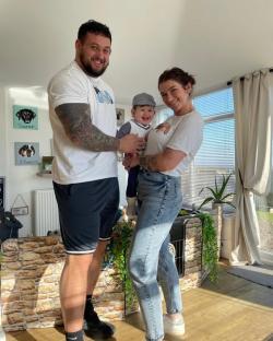 Family portrait of a man, woman, and baby.