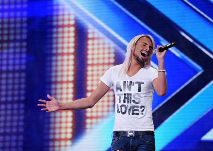 Rylan singing on stage during X Factor auditions.