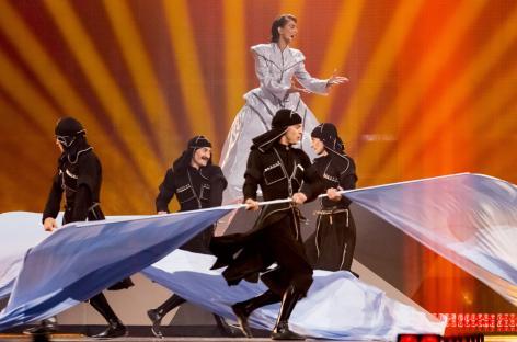 A singer and dancers performing on stage at the Eurovision Song Contest.