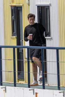 James Argent leaving a building, holding a coffee cup.