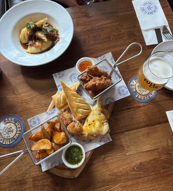 Food and drink items on a wooden table at The Golden Flake Tavern.