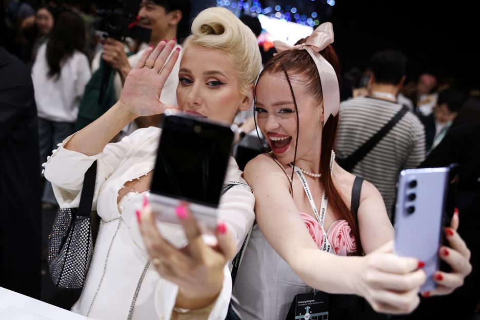 Two women taking selfies with Samsung Galaxy Z Flip 5 and Z Fold 5 phones.