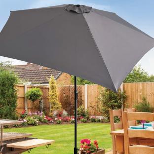 Grey crank and tilt parasol in a garden.