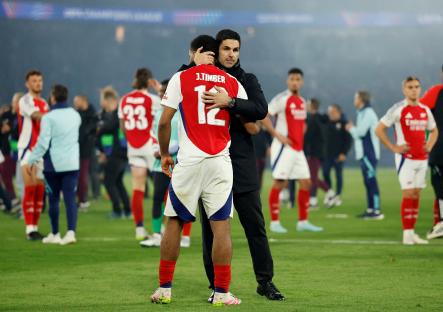 Arsenal's Jurrien Timber and manager Mikel Arteta embrace after a match.