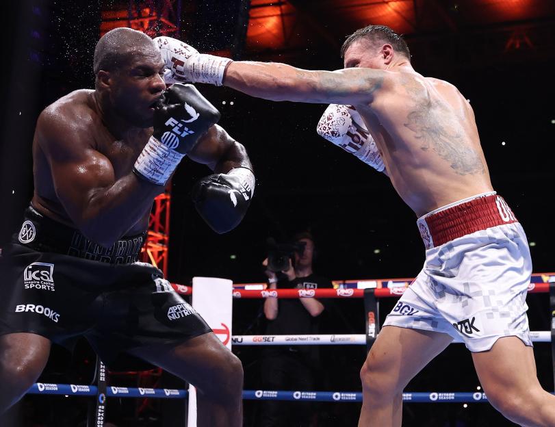 Oleksandr Usyk punches Daniel Dubois in a boxing match.