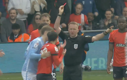 Referee showing a red card to a soccer player.