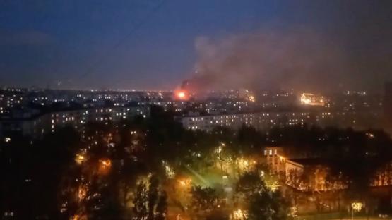 Nighttime view of a city with a large fire in the distance.