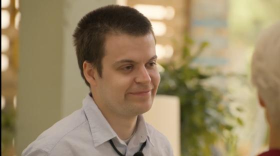 Man smiling and looking off to the side.