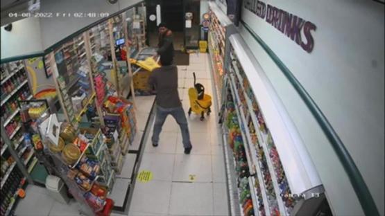 CCTV footage of a shop worker defending himself with a mop against a knife-wielding attacker.