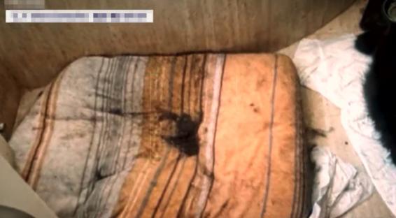 Soiled mattress in a neglected room.