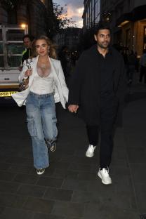 Georgia Harrison and Jack Stacey holding hands at a party.