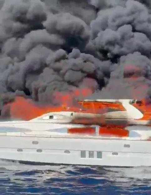 Burning yacht sinking in the ocean.