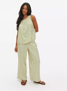 Woman wearing a green and white striped top and wide-leg pants.