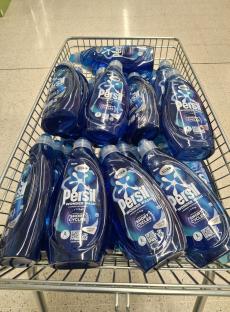 Shopping basket full of Persil Wonder Wash laundry detergent bottles.