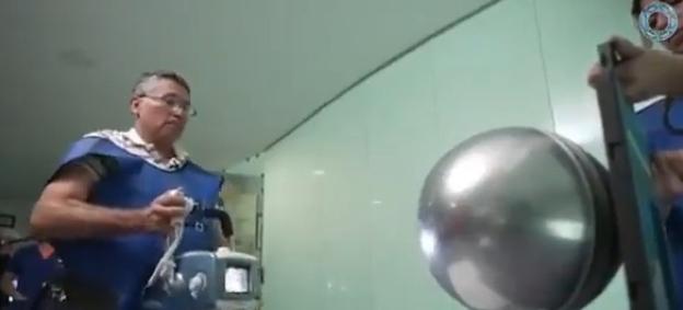 A radiologist examines a metallic sphere.