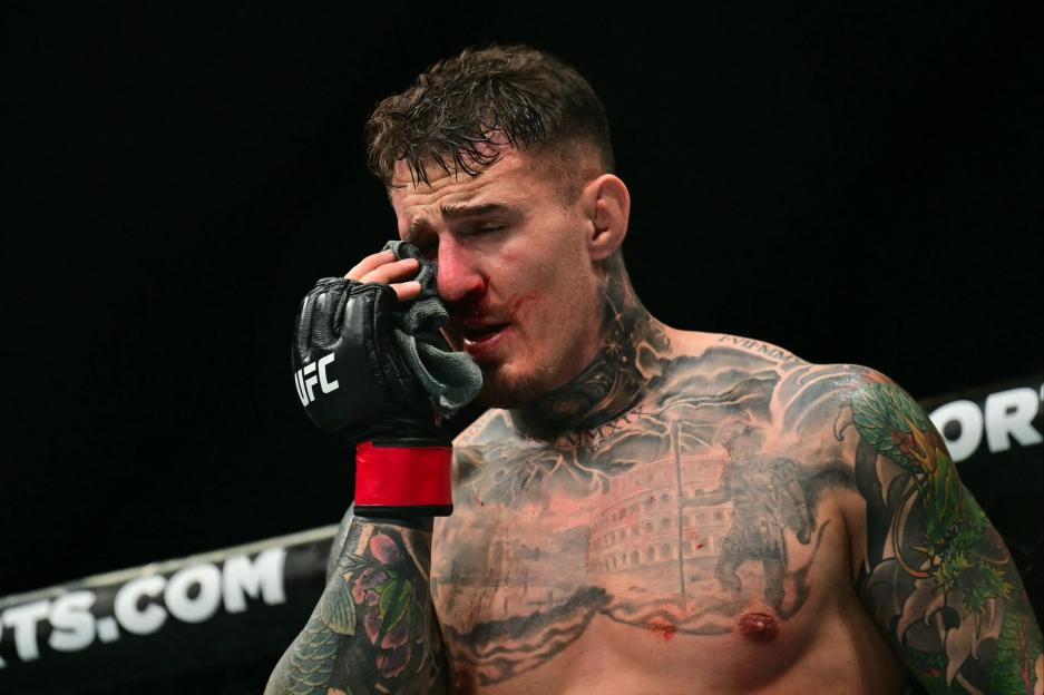Tom Aspinall reacts after being hit in the eye during his UFC heavyweight title bout.