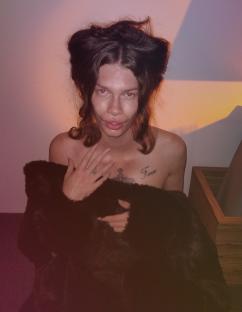 Woman with dark hair and a dark fur coat, after undergoing cosmetic procedures to resemble a cat.