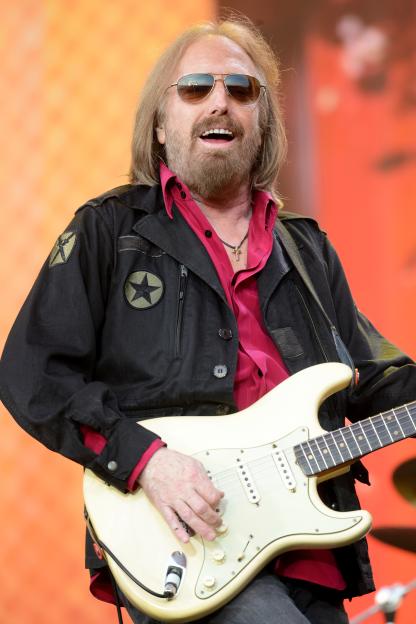Tom Petty playing guitar on stage.