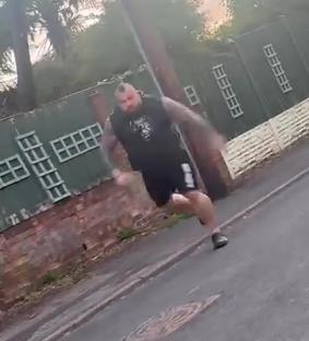 A former world's strongest man running down a street in slippers.