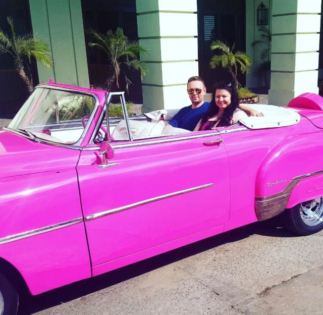 Couple in pink convertible in Cuba.