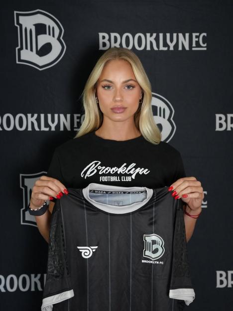 Ana Maria Markovic holding a Brooklyn FC jersey.