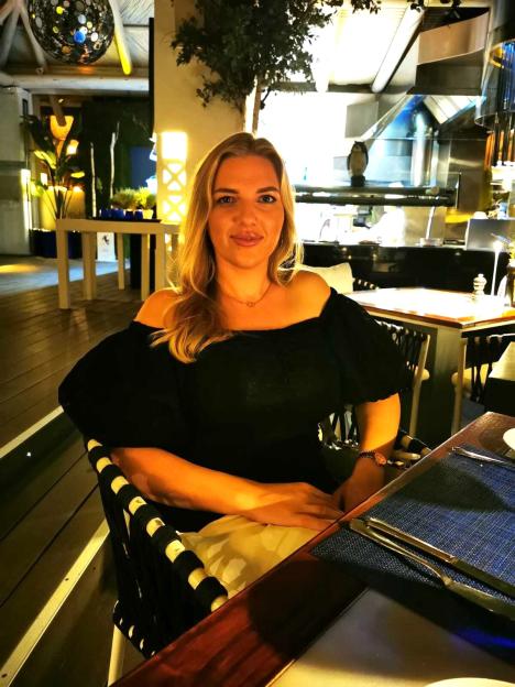 Anastasiia Chikina, 32, a Russian national, sitting at a table.