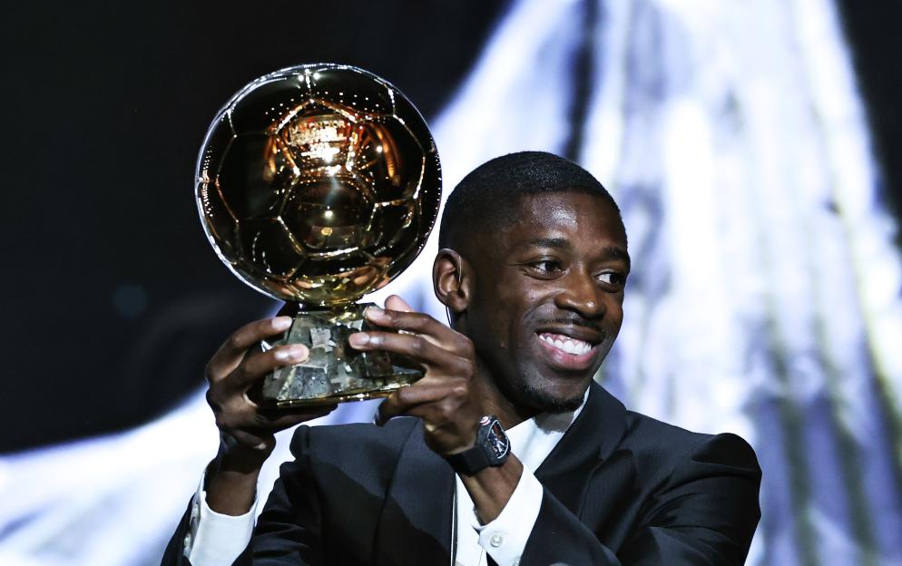 Ousmane Dembele holding the men's Ballon d'Or trophy.
