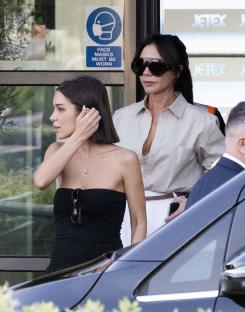 Victoria and Harper Beckham arriving at an airport.