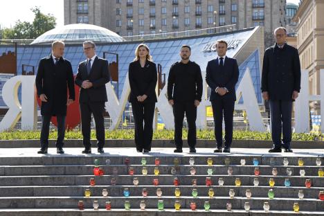Six European leaders stand on steps in Kyiv, Ukraine, with votive candles below them.