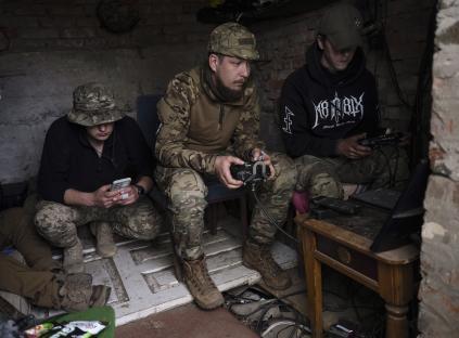 Ukrainian drone operators operating equipment in a makeshift command post.