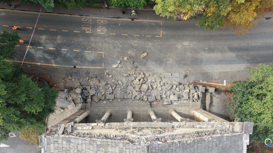 Aerial view of rubble from a collapsed building facade.