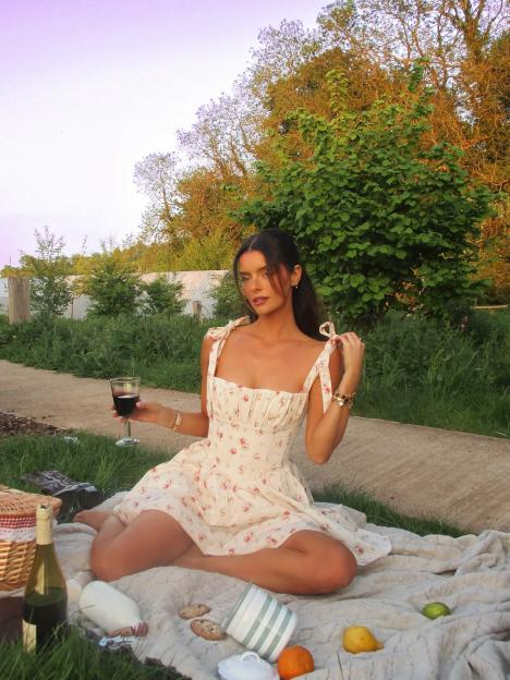 Woman in floral dress at a picnic.