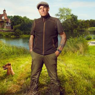 Vinnie Jones in the countryside with a dog.