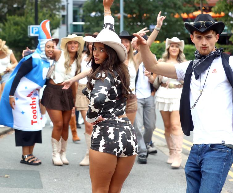 People in cowboy costumes participating in a pub crawl.
