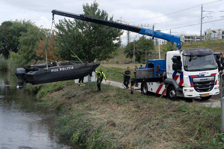 Police retrieving a boat from a canal.