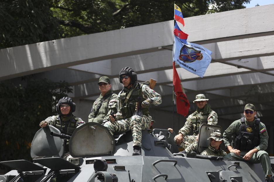 Venezuelan Defense Minister Vladimir Padrino Lopez and soldiers on a tank during a military exercise.