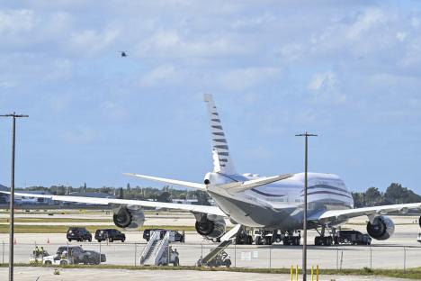 Photo of a Boeing 747 on an airport tarmac with President Trump's motorcade nearby.