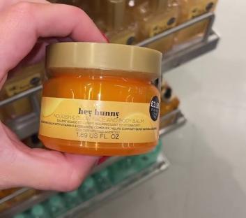 Hand holding a jar of Hey Hunny Nourish & Glow face and body balm.