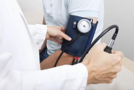 Doctor taking a patient's blood pressure.