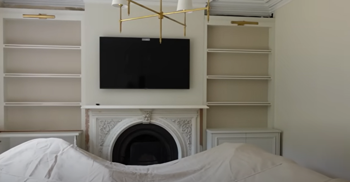 Living room with built-in shelves, fireplace, and television.