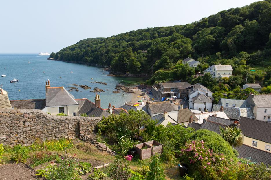 Overlooking Cawsand and Kingsand, Cornwall, England. A coastal village with houses, a beach, and boats.