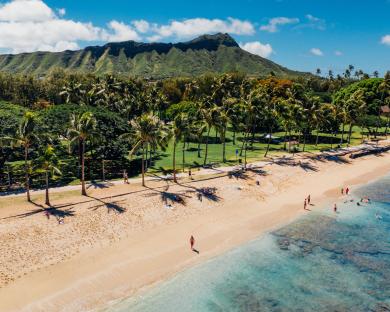 Aerial view of a Hawaiian beach with people swimming and relaxing.