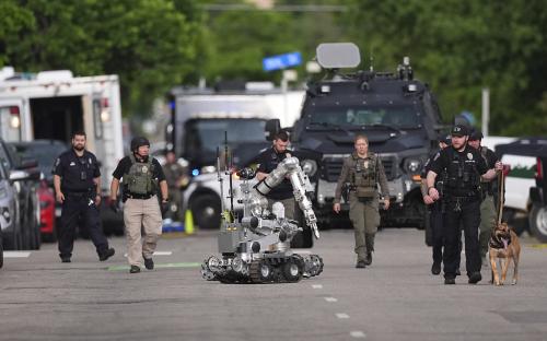 Law enforcement officials investigating an attack, using a robot.
