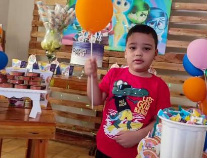 Boy at birthday party holding balloon.